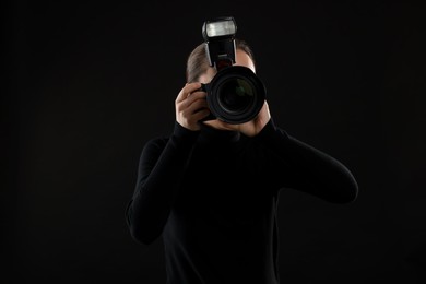 Professional photographer taking picture on black background