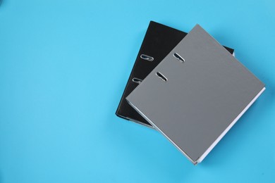 Photo of Office folders on light blue background, flat lay. Space for text