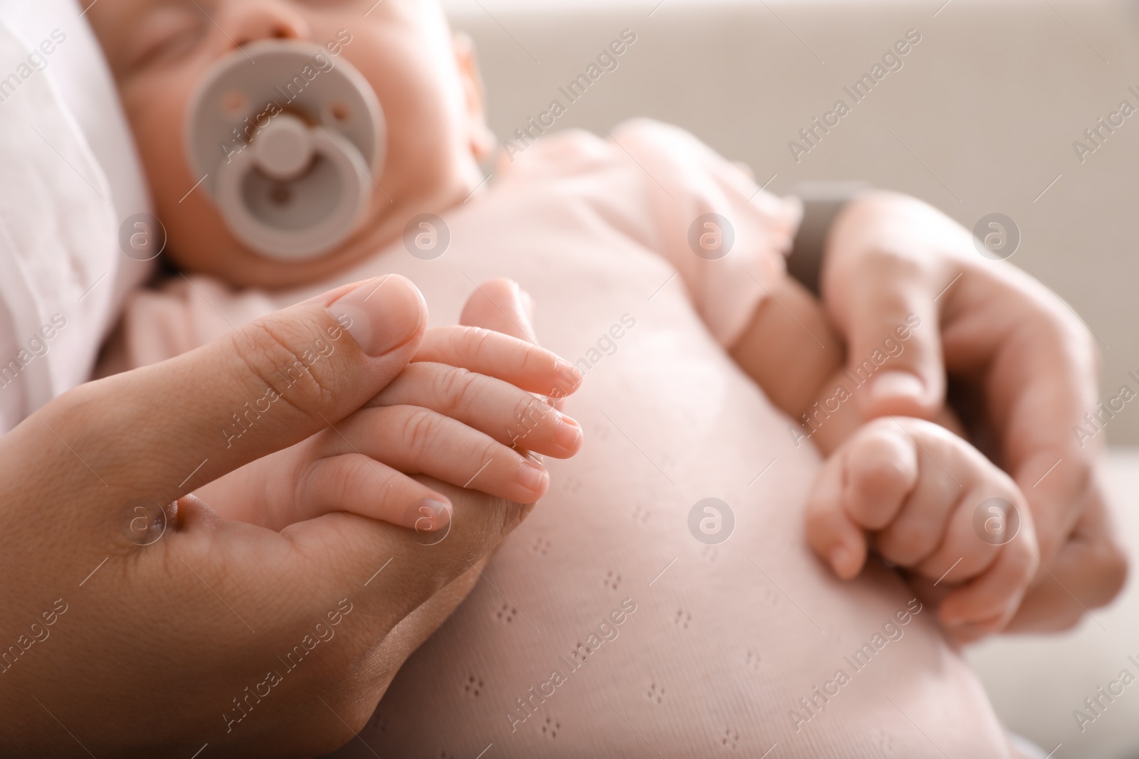 Photo of Mother with her cute sleeping baby, closeup of hands