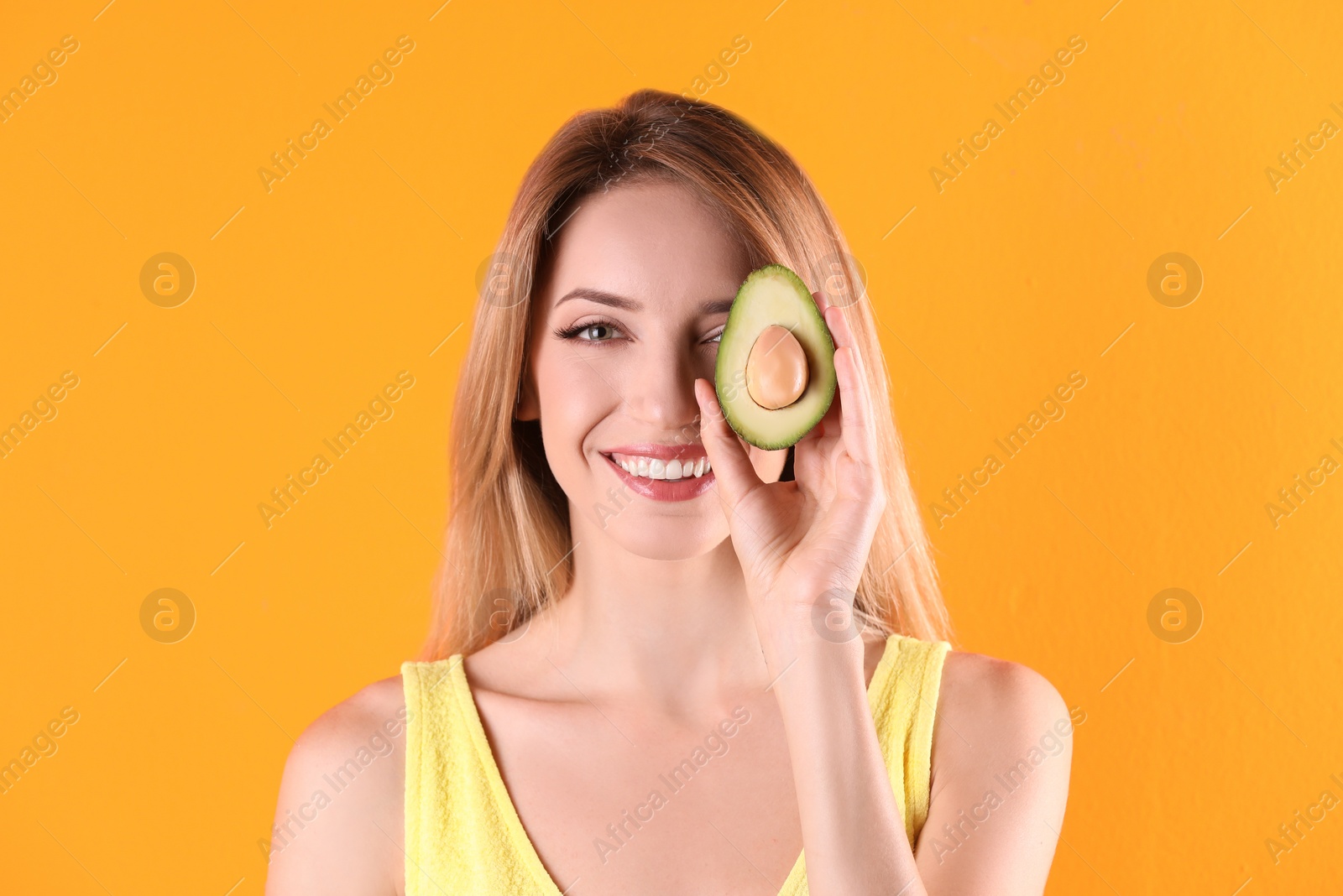 Photo of Portrait of young beautiful woman with ripe delicious avocado on color background