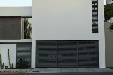 Photo of Closed grey metal gates near estate with cactuses