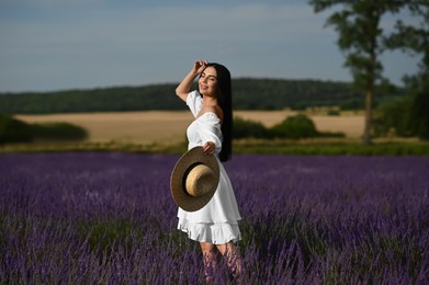 Photo of Beautiful young woman walking in lavender field