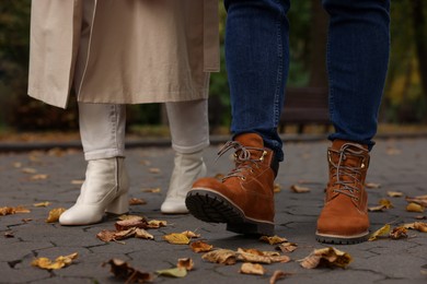 Photo of Young couple walking in autumn park, closeup