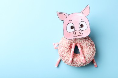 Photo of Funny pig made with donut and straws on light blue background, flat lay. Space for text