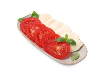 Photo of Plate of delicious Caprese salad with tomatoes, mozzarella and basil isolated on white