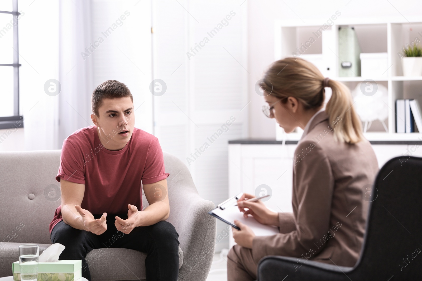 Photo of Psychotherapist working with young man in office