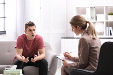 Psychotherapist working with young man in office