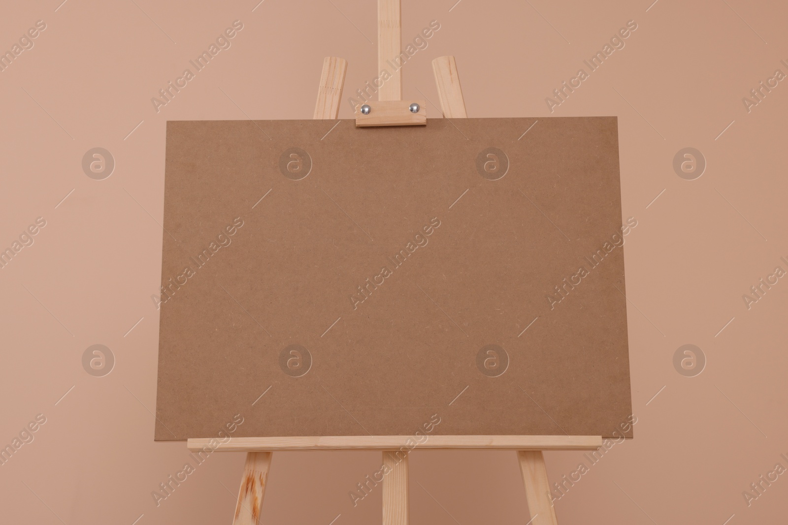 Photo of Wooden easel with blank board on beige background