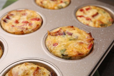 Freshly baked bacon and egg muffins with cheese in tin, closeup