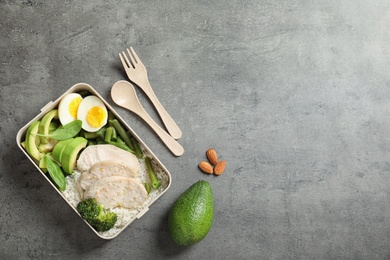 Flat lay composition with container of natural protein food on gray background. Space for text