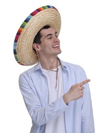 Photo of Young man in Mexican sombrero hat pointing at something on white background