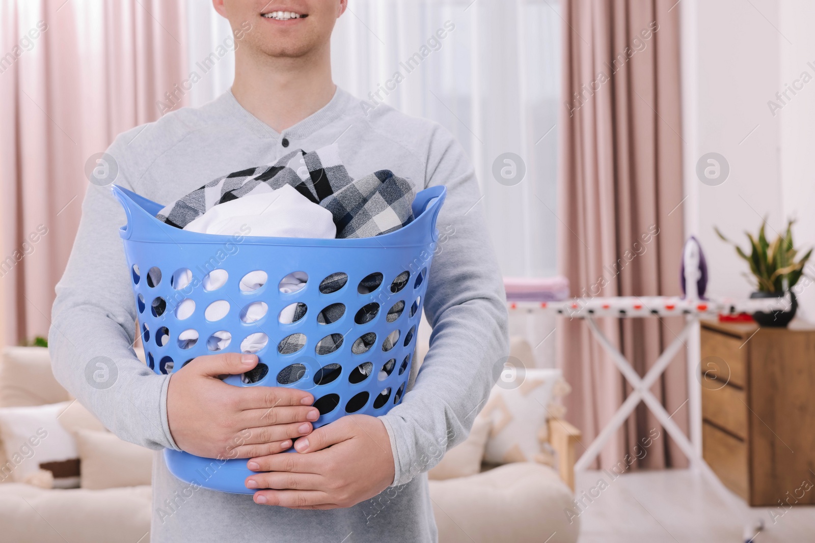 Photo of Man with basket full of laundry at home, closeup