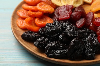 Photo of Delicious dried fruits on light blue wooden table, closeup