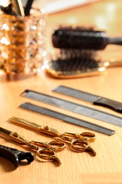 Photo of Hairdresser tools. Different scissors and combs on wooden table, closeup