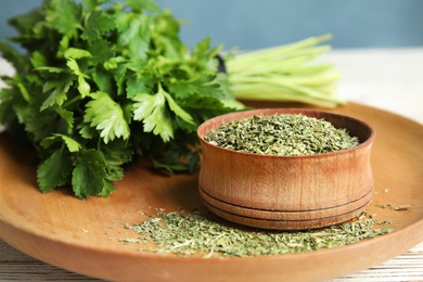 Photo of Plate with fresh and dried parsley on table, closeup