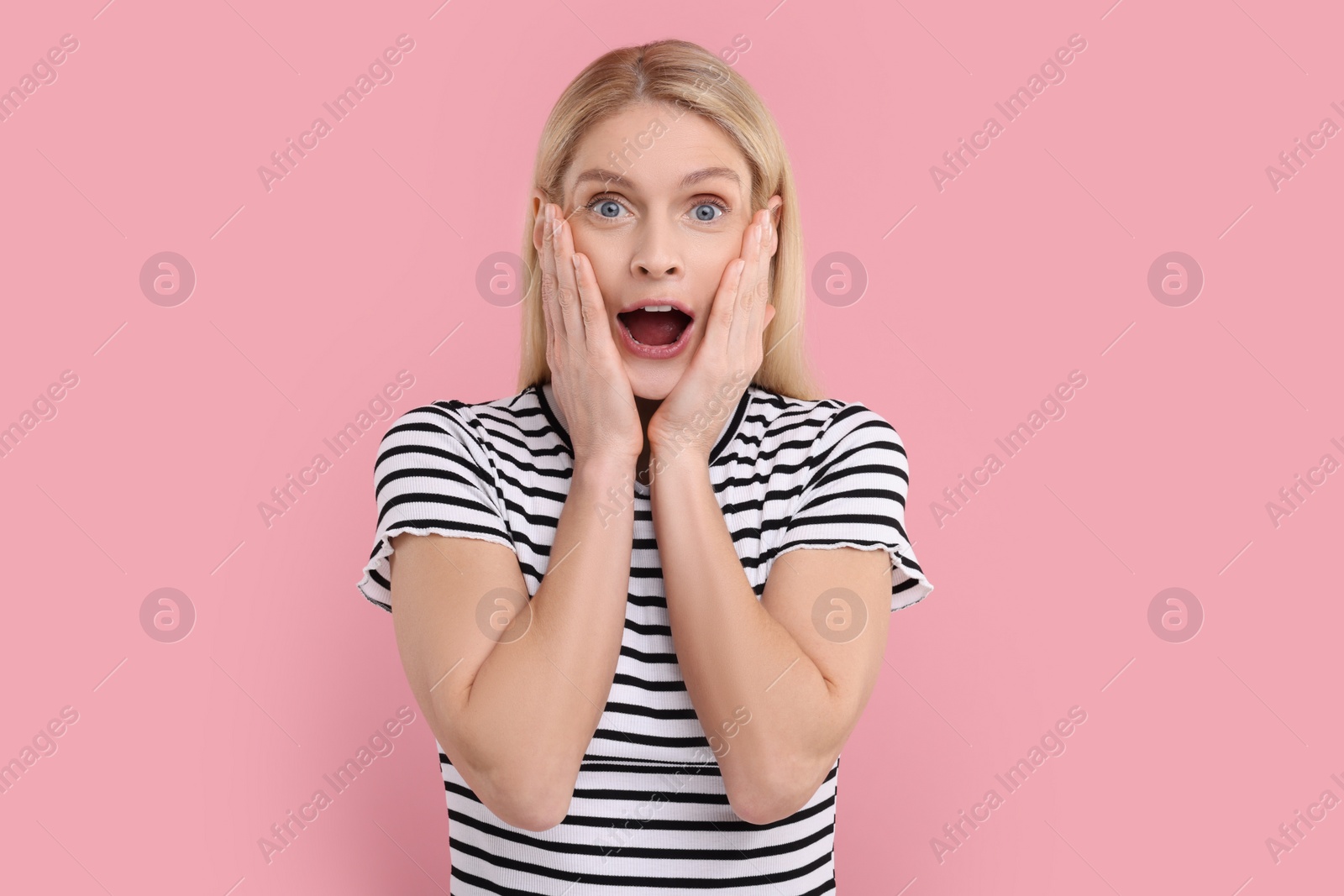 Photo of Portrait of surprised woman on pink background