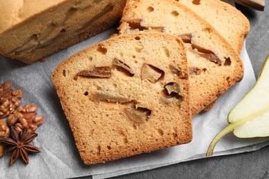 Photo of Composition with pear bread on black slate table, closeup. Homemade cake