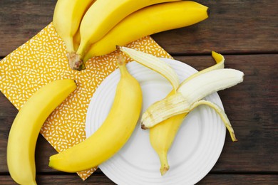 Many delicious ripe bananas on wooden table, flat lay