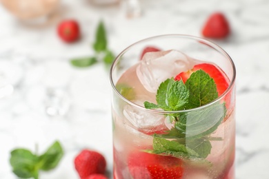 Photo of Glass of refreshing drink with strawberry and mint on table, closeup view. Space for text