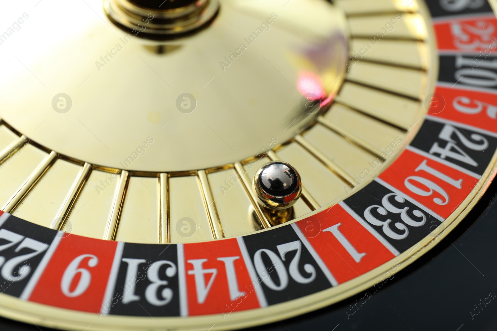 Photo of Roulette wheel with ball, closeup. Casino game