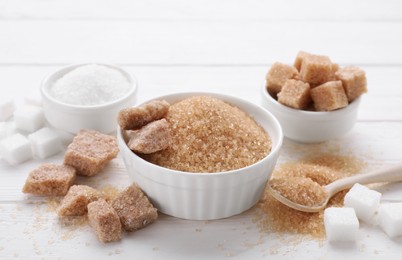 Photo of Different types of sugar on white wooden table