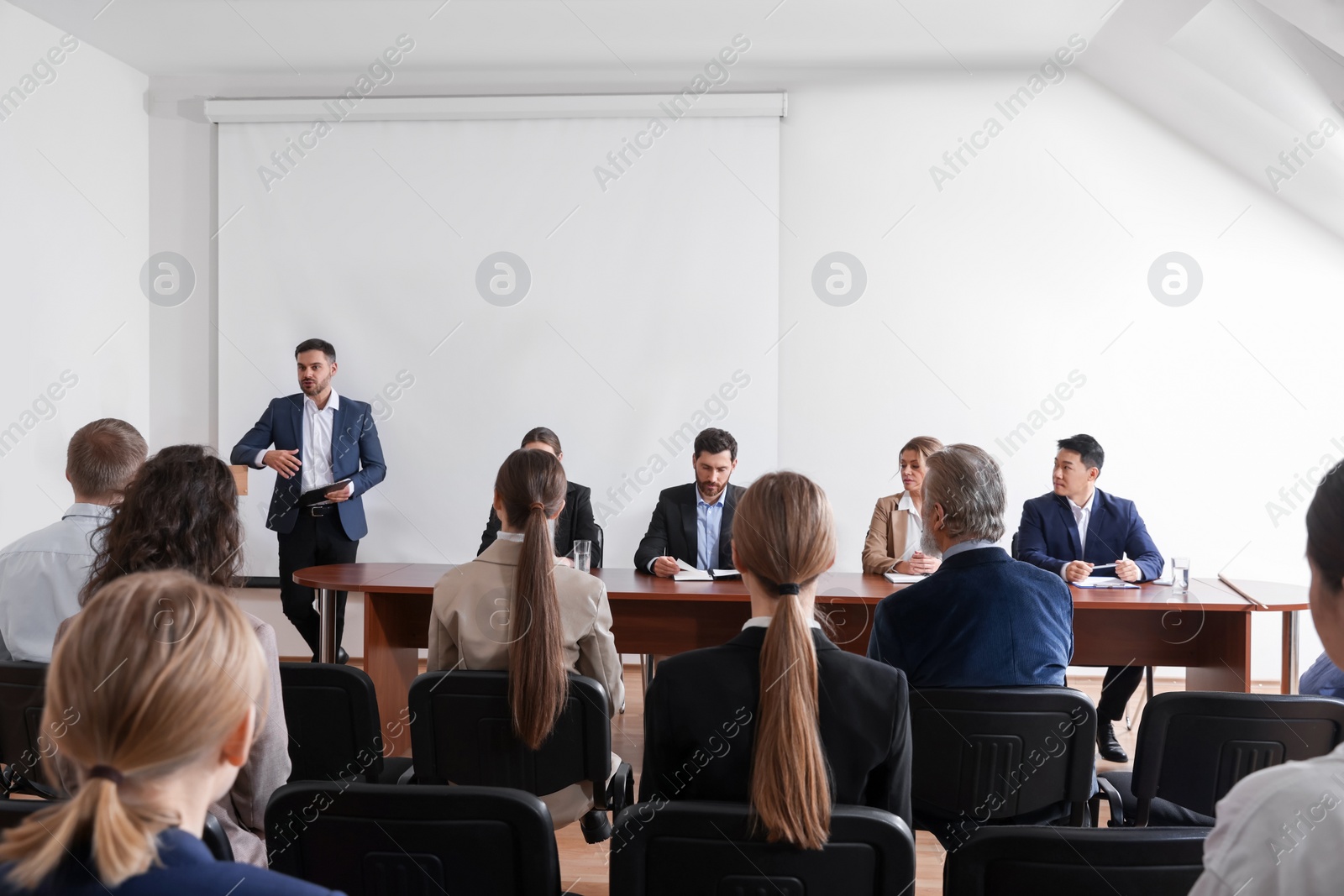 Photo of Business conference. People in meeting room listening to speaker report