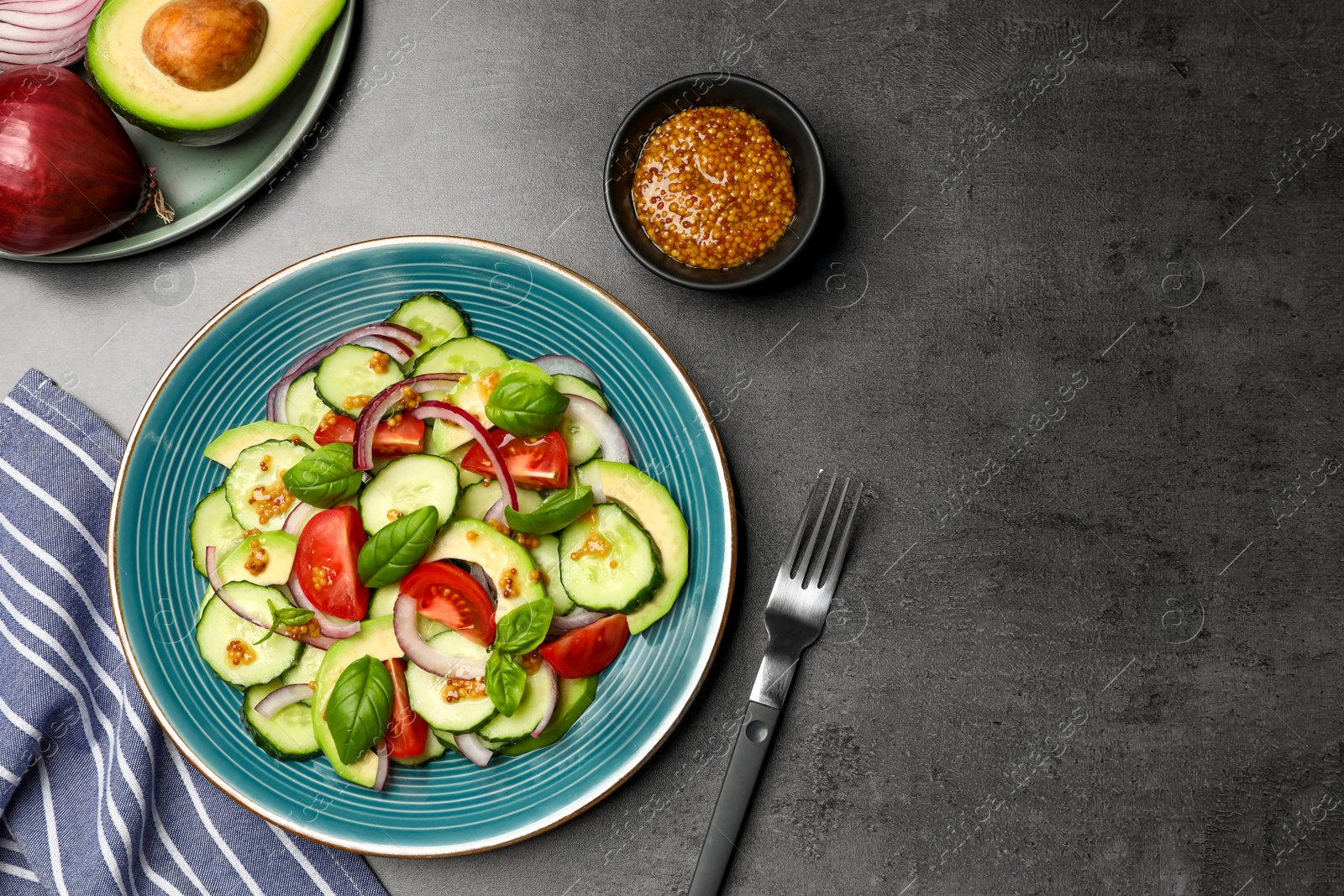 Photo of Tasty salad with cucumbers served on grey table, flat lay. Space for text