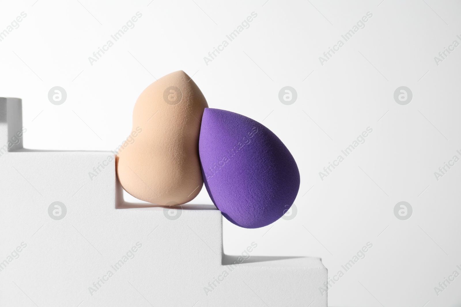 Photo of Stylish presentation of makeup sponges on white background