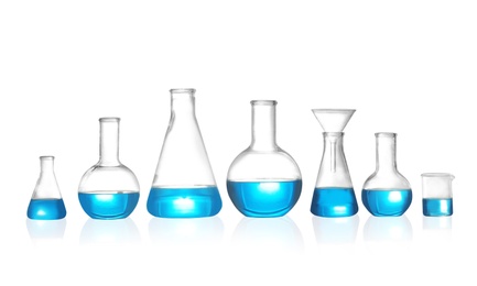 Photo of Laboratory glassware with liquid on white background. Solution chemistry