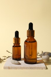 Composition with bottles of cosmetic serum on beige background