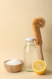 Photo of Eco friendly cleaning supplies for washing dishes on beige background. Conscious consumption