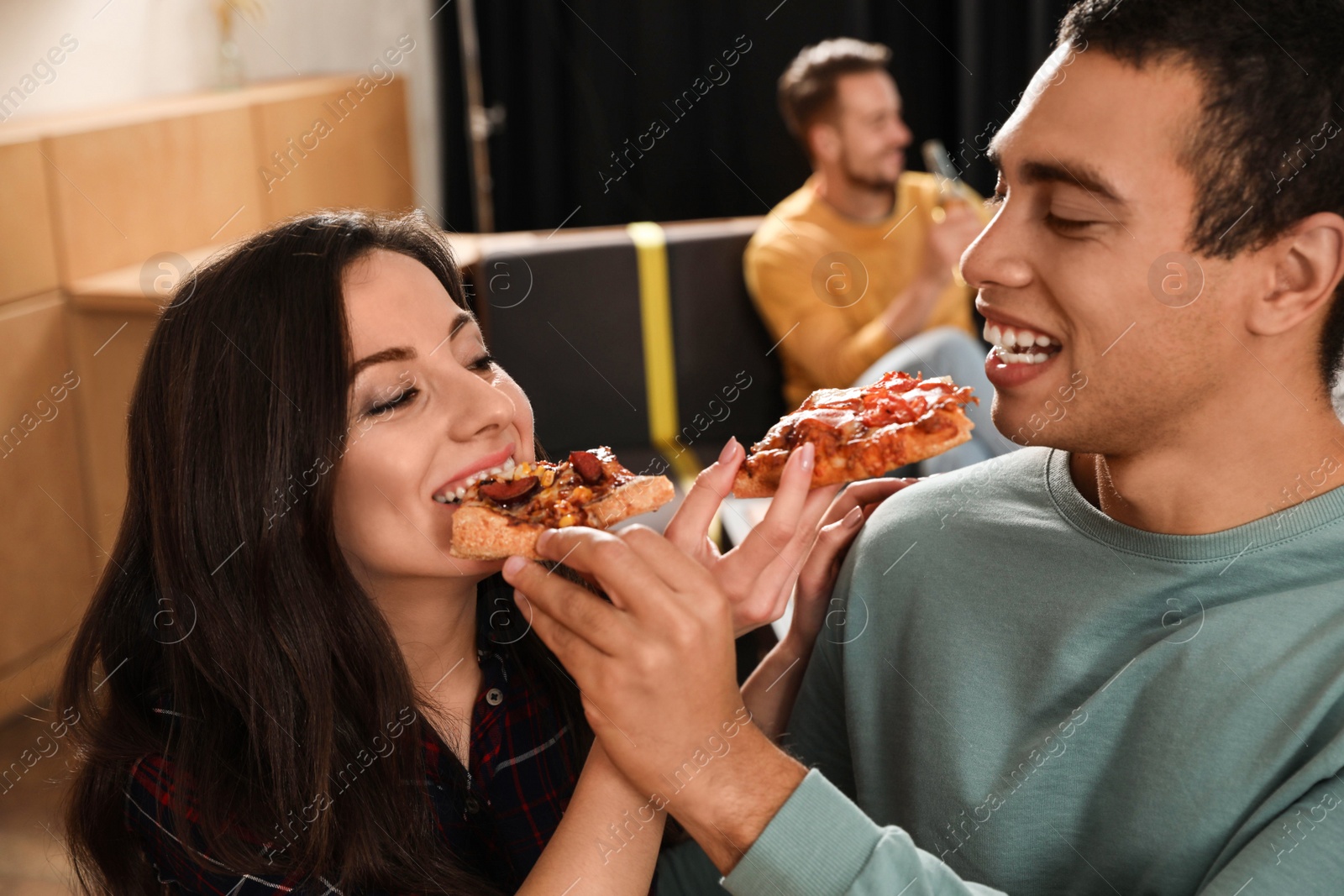 Photo of Young couple eating delicious pizza in cafe, closeup