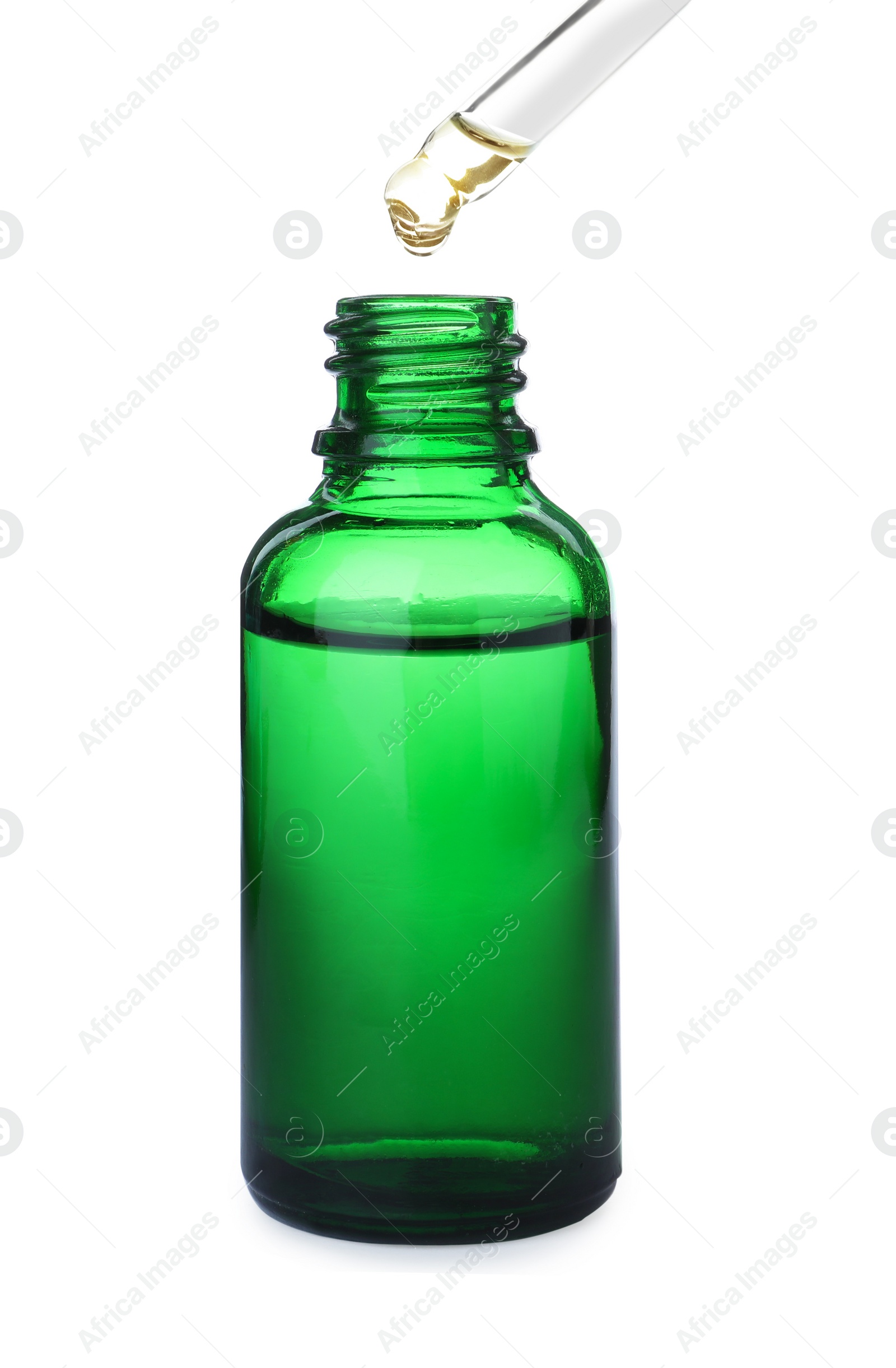 Photo of Dripping essential oil from pipette into bottle isolated on white