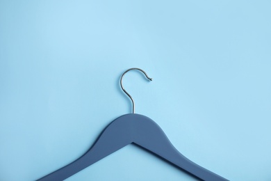 Photo of Empty wooden clothes hanger on color background. Space for text