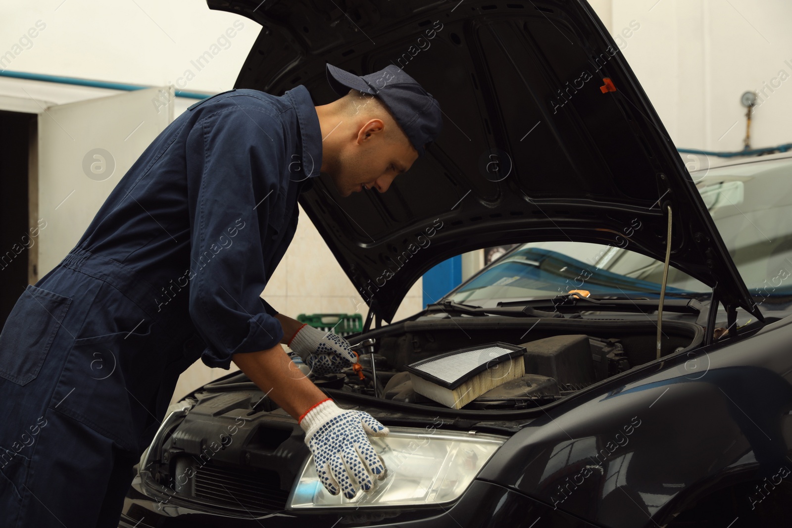 Photo of Professional mechanic fixing modern car at automobile repair shop