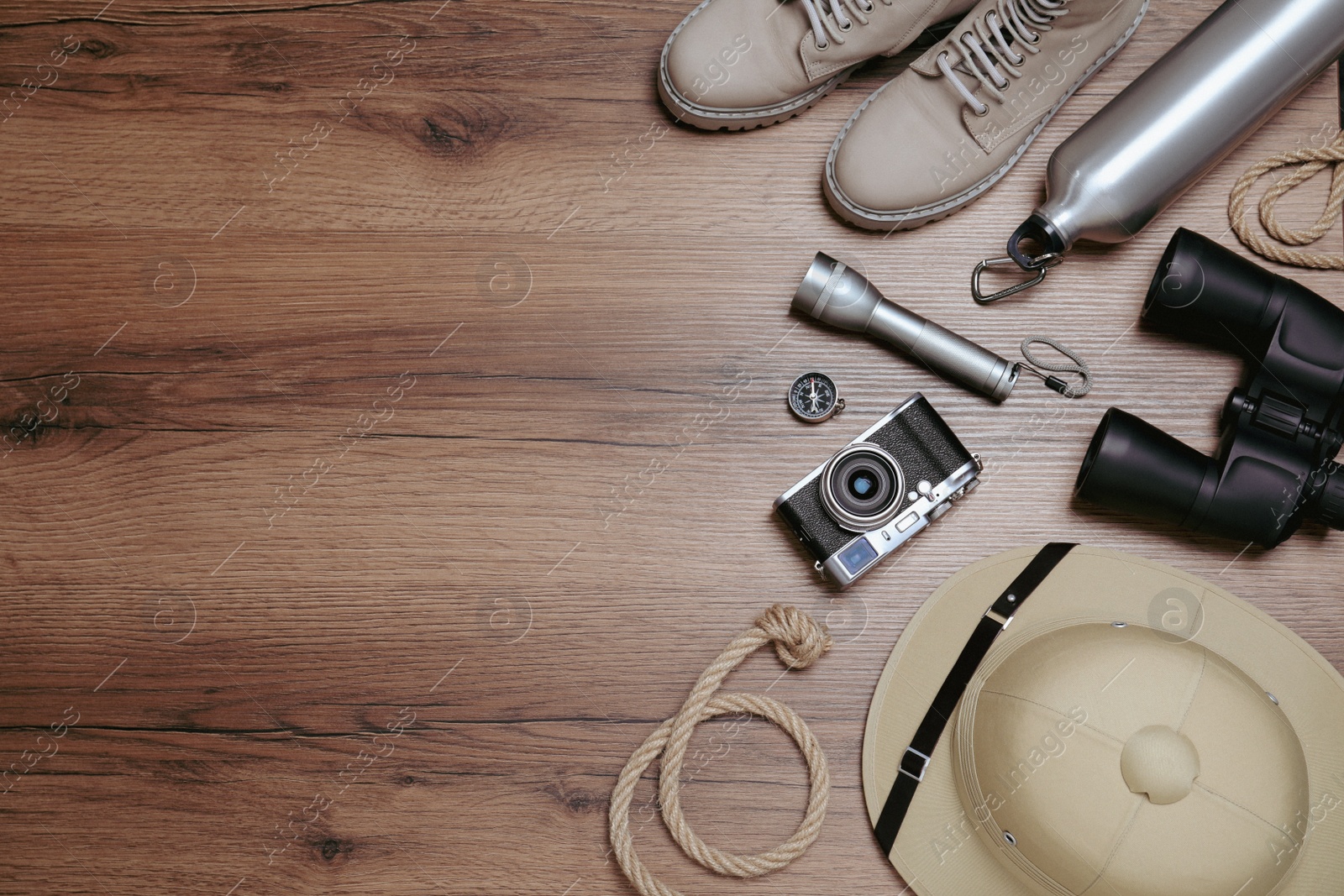 Photo of Flat lay composition with safari accessories on wooden background, space for text