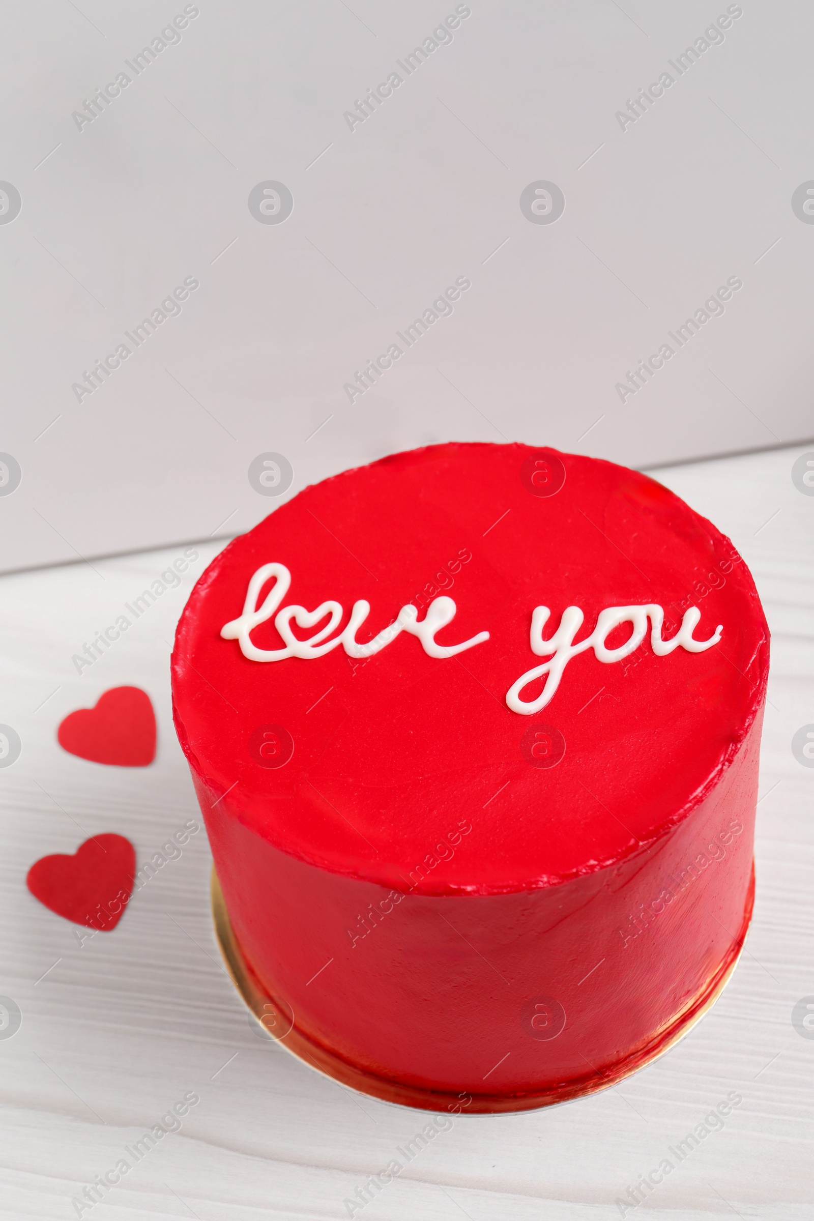 Photo of Bento cake with text Love You and takeaway packaging on white wooden table