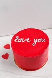 Bento cake with text Love You and takeaway packaging on white wooden table