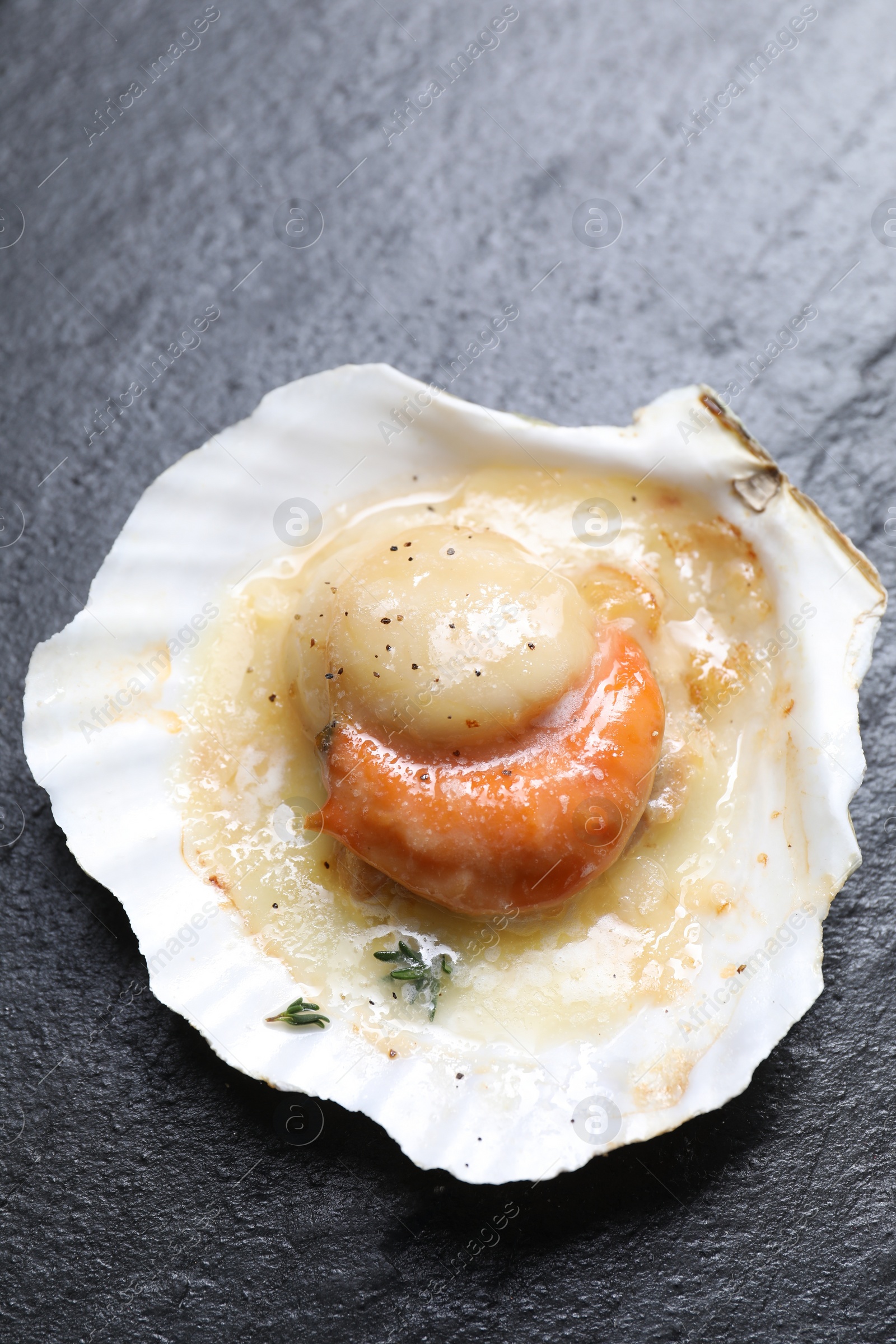 Photo of Fried scallop in shell on black table, top view