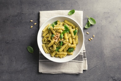 Photo of Plate of delicious basil pesto pasta on gray table, top view