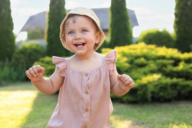 Photo of Cute little girl wearing stylish clothes outdoors on sunny day