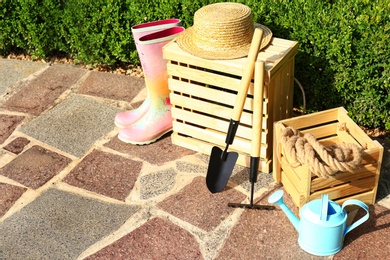 Photo of Wooden crates and gardening tools on stone path at backyard