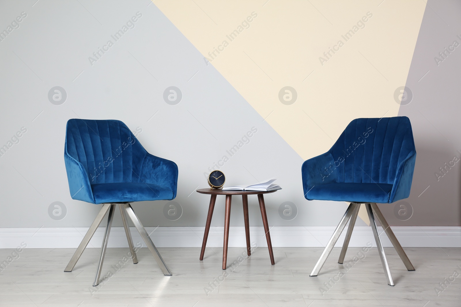 Photo of Room interior with modern blue chairs and table at color wall