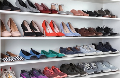 Photo of Shelving unit with different shoes. Element of dressing room interior