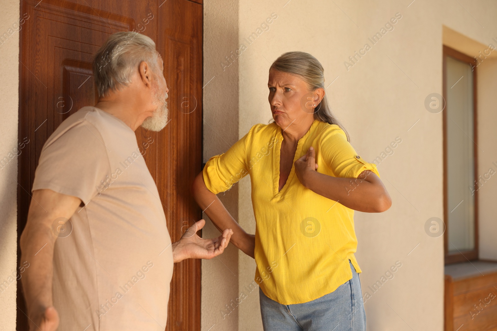 Photo of Emotional neighbours having argument near house outdoors