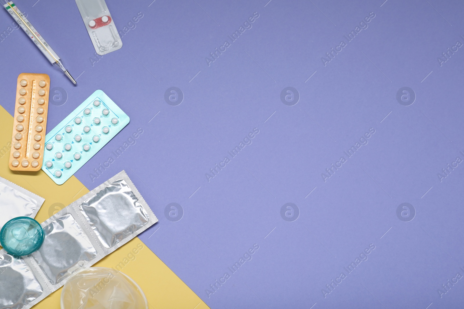 Photo of Contraceptive pills, condoms and thermometer on color background, flat lay with space for text. Choice of birth control method