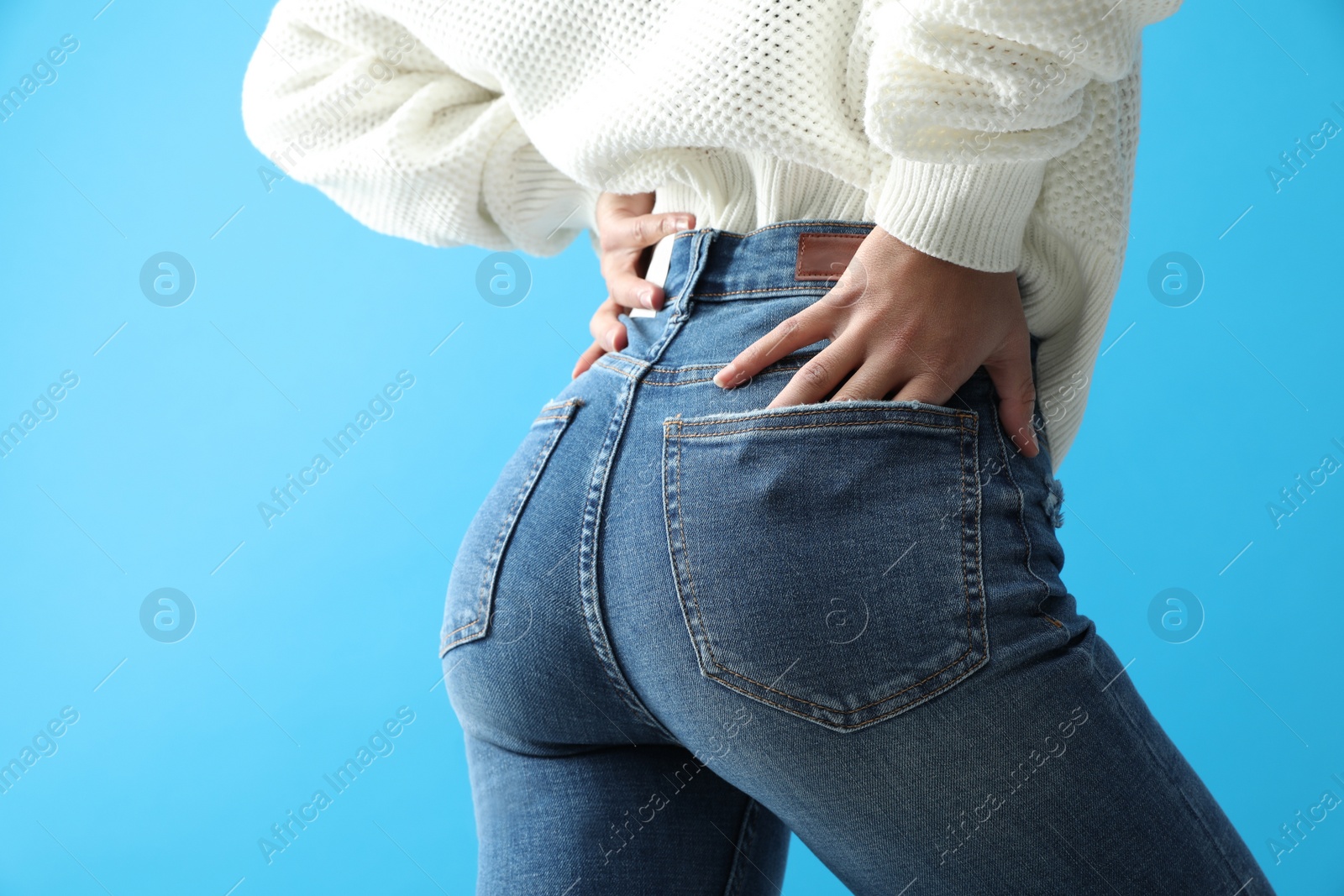 Photo of Woman wearing jeans on blue background, closeup