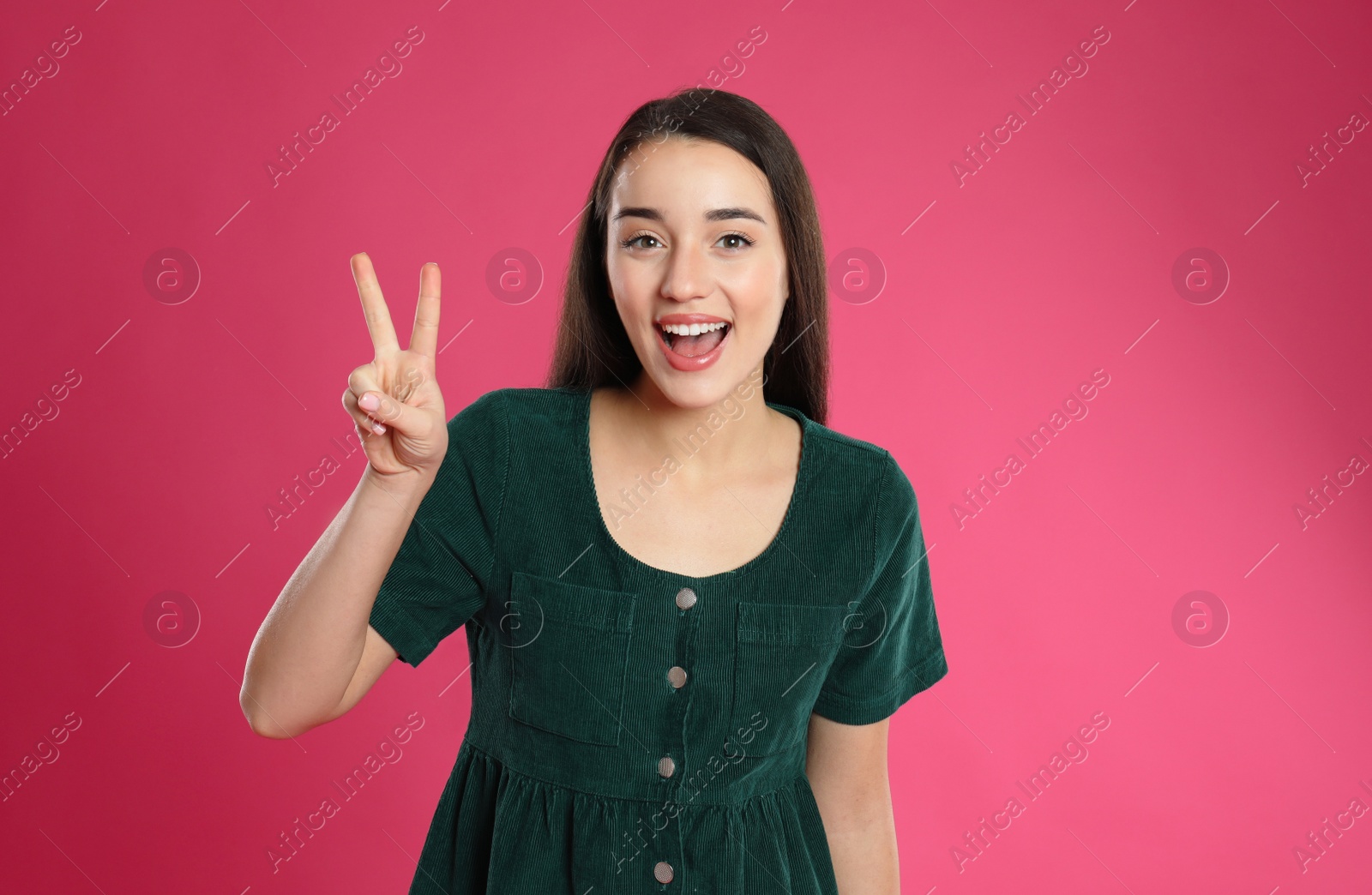 Photo of Woman showing number two with her hand on pink background