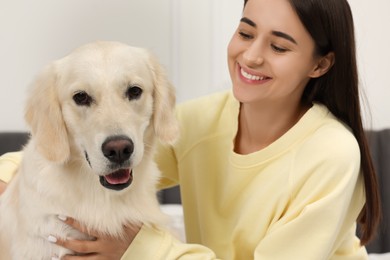 Happy woman with cute Labrador Retriever dog at home. Adorable pet