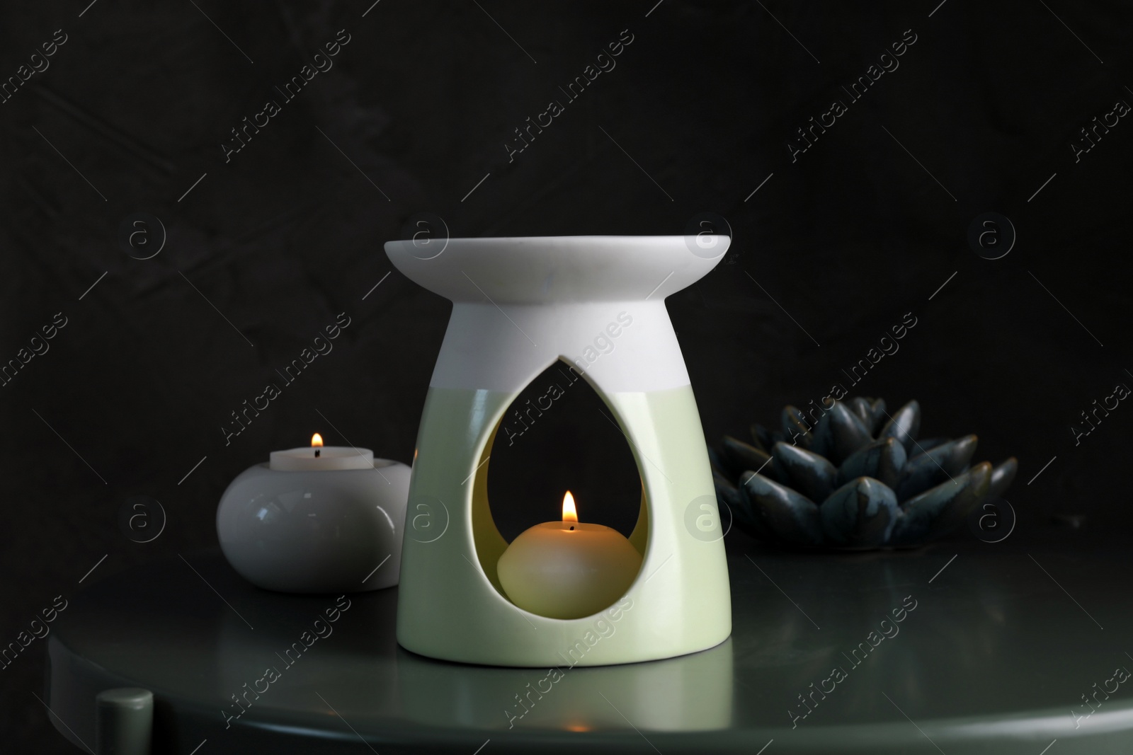 Photo of Aroma lamp with small candle on black table